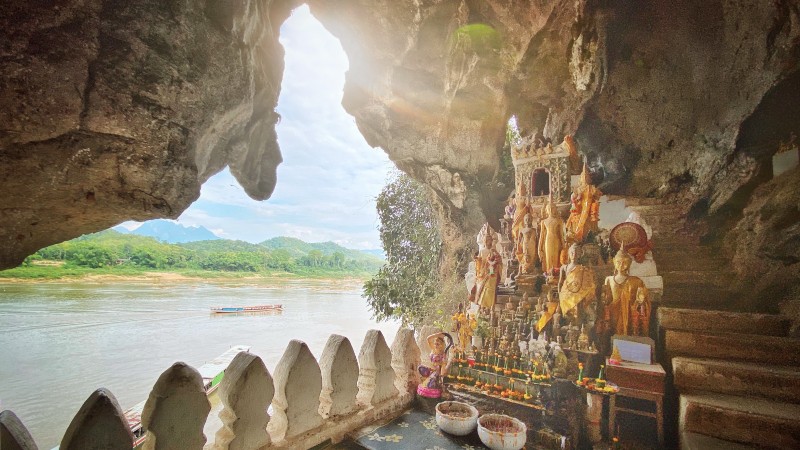 Buddha statuer, ofringsmat, trapper, fjell og elv