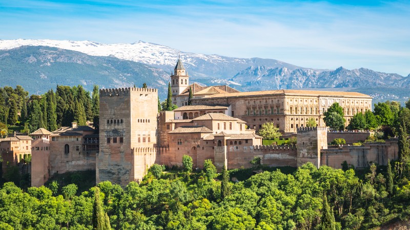 Granada med Alhambra slott, festningsbygg med fjell i bakgrunn