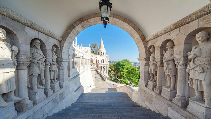 En liten tunnel ved en borg med gamle statuer p� hver side. 