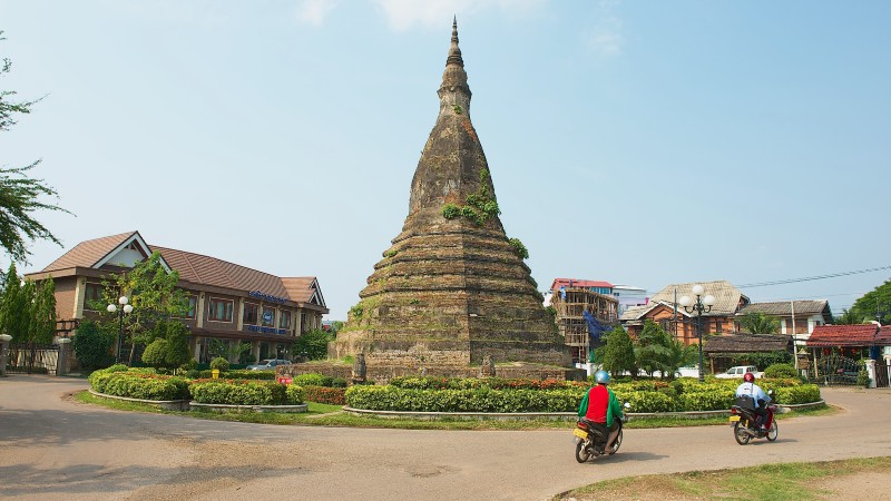 en stupar, noen p� mopeder, vei og hus i bakgrunn
