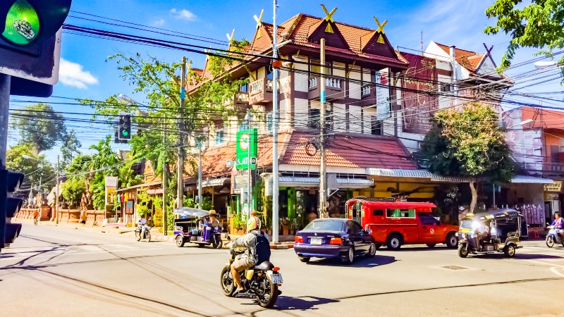 mann p� motorsykkel, biler, trafikklys og butikk, restaurant