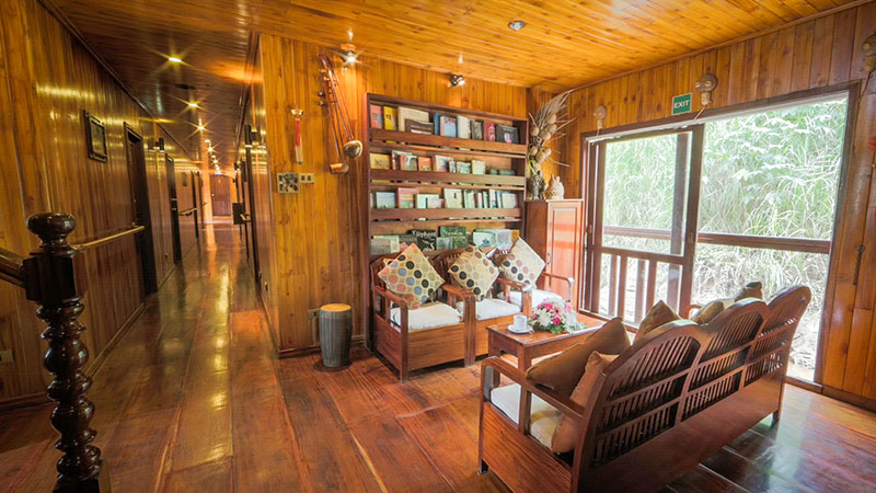 et omr�det med b�ker, sofa, bord og et stort vindu p� skipet 