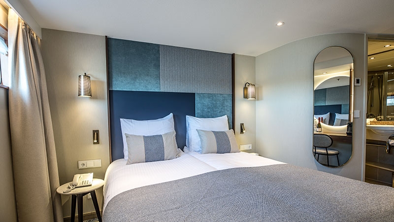 Dobbeltseng med speil p� veggen i standardlugar.