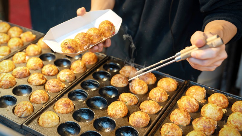 En person lager takoyaki-baller
