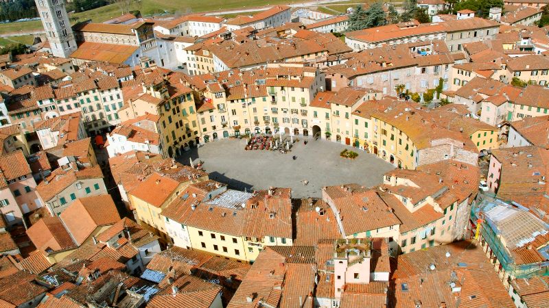 Ovalt torg i Lucca omkranset av gamle bygninger