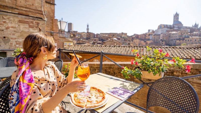 En kvinner nyter lunsj med fin utsikt utover Siena