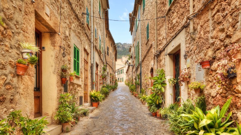 En liten gate med gamle steinhus p� hver side i Valldemossa