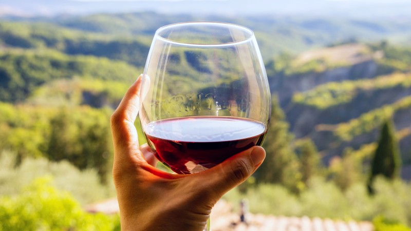 R�dvinsglassmed vinmarker i bakgrunnen