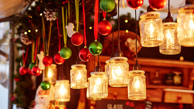Julepynt og lys henger i en markedsbod