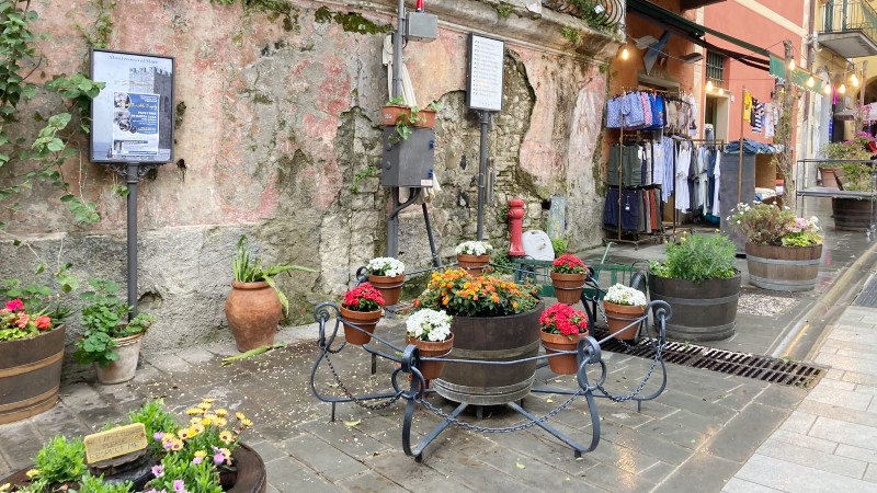 slitt vegg, nydelige blomsterkasser p� bakken , en klesbutikk med klesstativ utenfor butikken