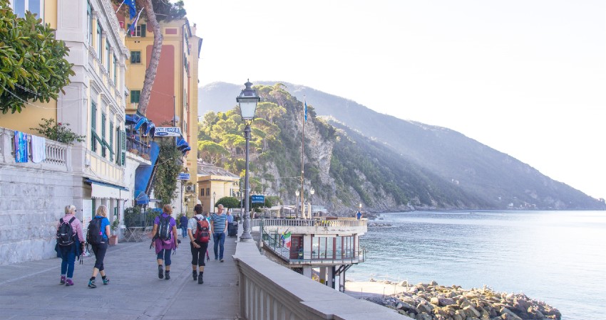 mennsker som g�r p� en asfaltert gate n�rme sj�en