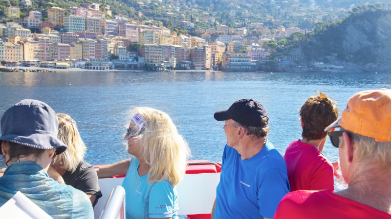 mennesker i b�t hvor man ser ut over landskapet langs kysten.