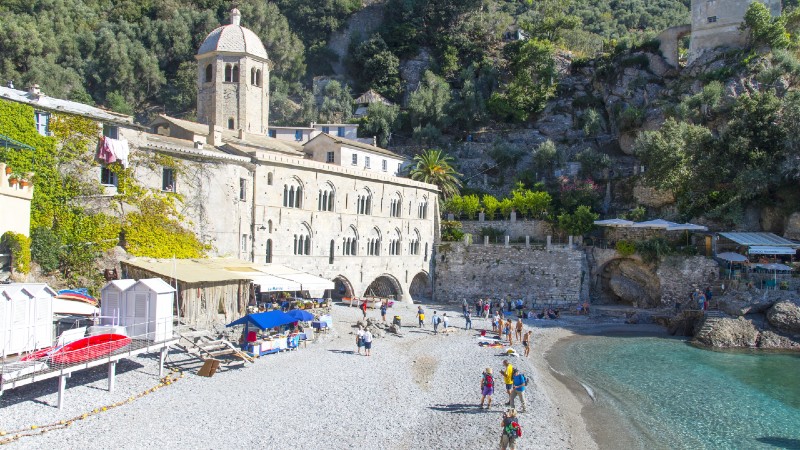 strand, hav, hvit stor bygning og mennesker 