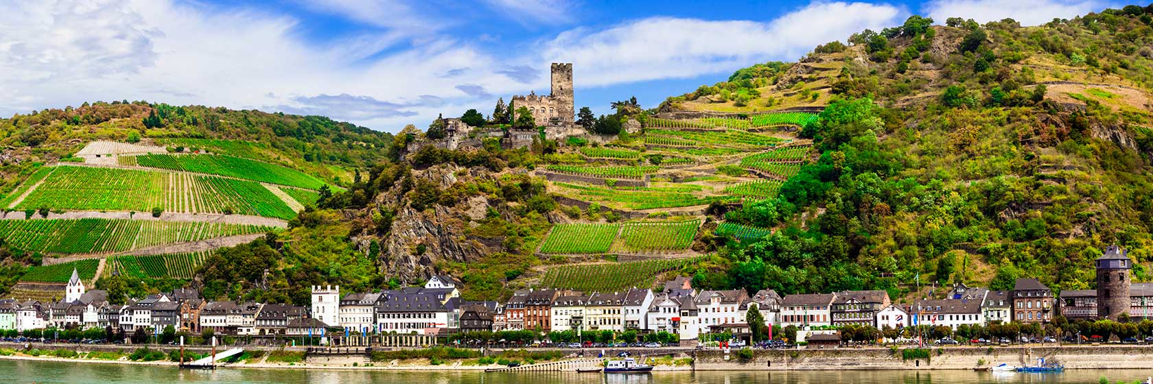 Rhinen En elv renner forbi en landsby i vakkert landskap. Et slott på toppen av en ås.